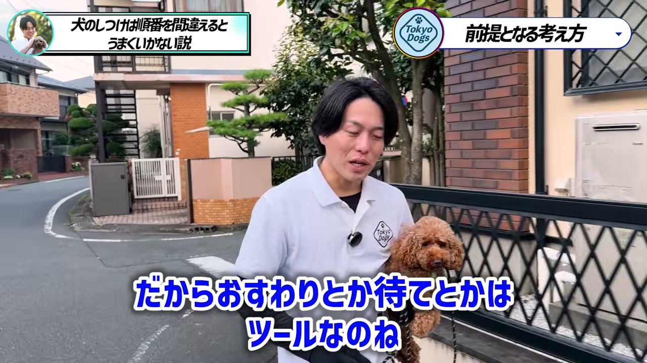 トイプードルを抱き、おすわりや待ては道具だと説明する松尾邑仁