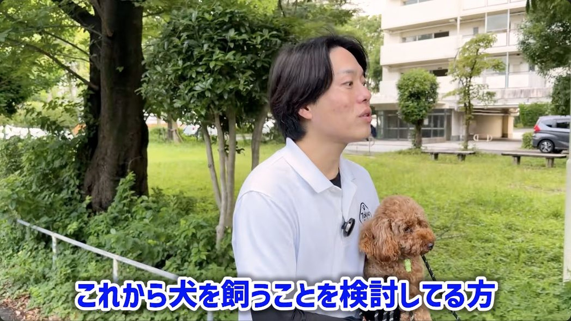 トイプードルを抱き、これから犬を迎える人へ話す松尾邑仁